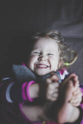 Portrait of giggling toddler girl, top view - IHF00180