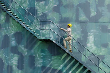 Hispanic worker climbing water tower - BLEF10467