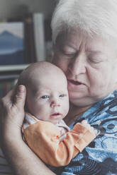 Portrait of grandmother with baby boy on her arms - IHF00189