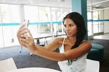 Multi-ethinsche Frau macht Selfie am Tisch - BLEF10558