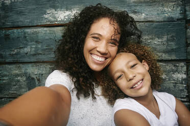 Mixed race mother and daughter taking selfie - BLEF10588