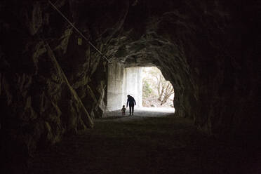 Kaukasische Mutter und Tochter gehen in einer Höhle spazieren - BLEF10613