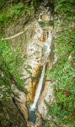 Luftaufnahme eines hohen Wasserfalls, umgeben von viel Vegetation im Soca-Fluss. - AAEF00026