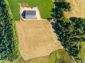Luftaufnahme einer Scheune und Strohballen auf einem Feld in Correze, Frankreich. - AAEF00067