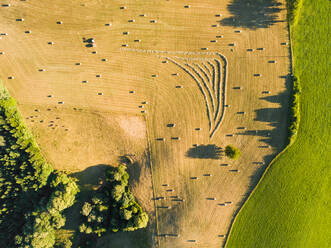 Luftaufnahme eines Traktors bei der Ernte von Strohballen auf einem Feld in Correze, Frankreich. - AAEF00089