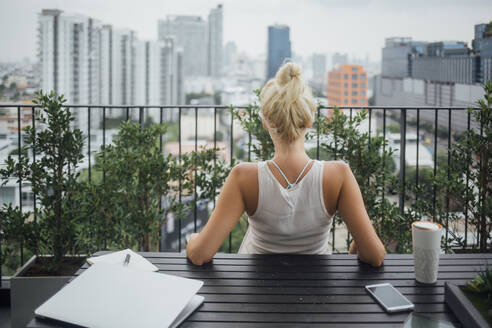 Caucasian woman sitting on balcony - BLEF10716