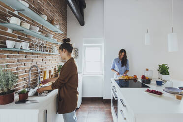 Caucasian women cooking in kitchen - BLEF10741