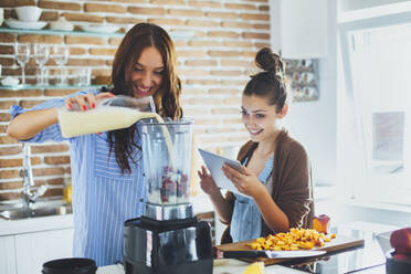 Kaukasische Frauen machen Smoothie in der Küche - BLEF10743