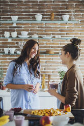 Caucasian women talking in kitchen - BLEF10745