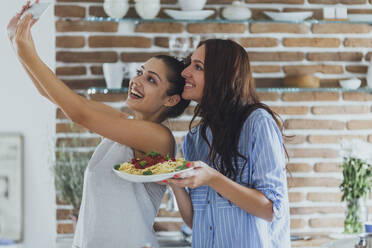 Kaukasische Frauen machen Selfie in der Küche mit Nudeln - BLEF10760