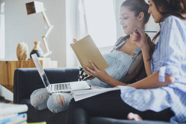 Kaukasische Frauen studieren auf dem Sofa - BLEF10763