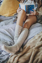 Frau liest Buch auf dem Bett - BLEF10789