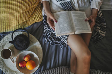 Frau liest Buch auf dem Bett - BLEF10790