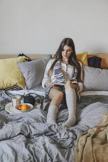 Woman reading book on bed - BLEF10793