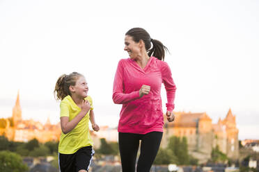 Caucasian mother and daughter jogging outdoors - BLEF10797