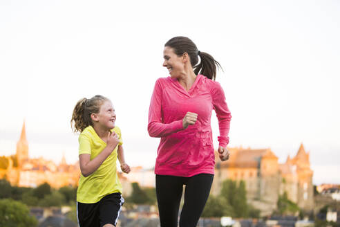 Kaukasische Mutter und Tochter joggen im Freien - BLEF10797