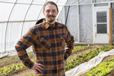 Caucasian farmer standing in greenhouse - BLEF10854