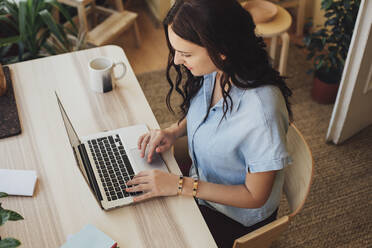 Caucasian woman using laptop at desk - BLEF10931