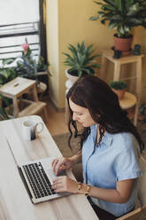 Caucasian woman using laptop at desk - BLEF10932