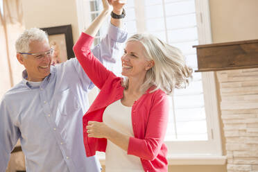 Caucasian couple dancing in living room - BLEF10942