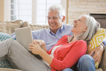 Caucasian couple using laptop on sofa - BLEF10946