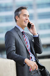 Mixed race businessman talking on cell phone - BLEF10950