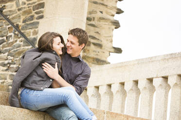 Caucasian couple hugging on castle steps - BLEF10994