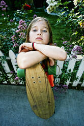 Caucasian girl holding skateboard on sidewalk - BLEF11062