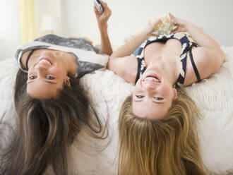 Teenage girls laying on bed upside-down - BLEF11129