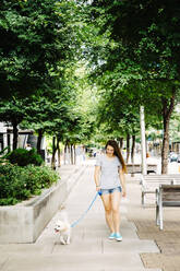 Caucasian woman walking dog in park - BLEF11176