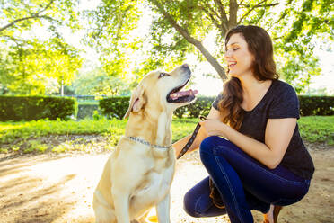 Caucasian woman petting dog outdoors - BLEF11182