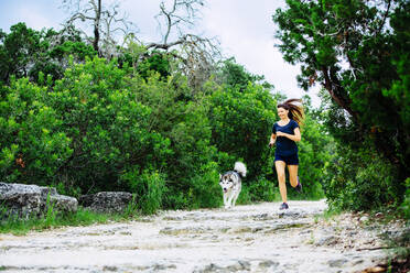 Kaukasische Frau joggt mit Hund - BLEF11189