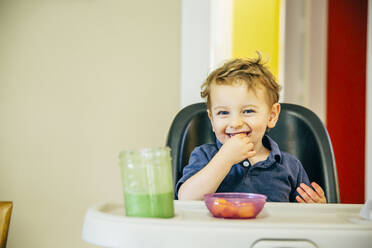 Caucasian boy eating in high chair - BLEF11196