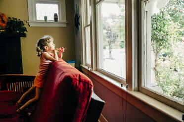 Kaukasisches Mädchen schaut aus dem Fenster - BLEF11200