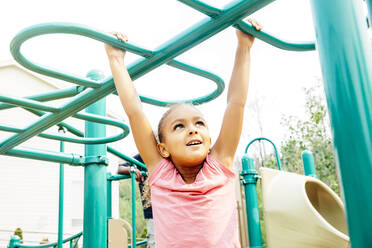 Mixed race girl playing on playground - BLEF11205
