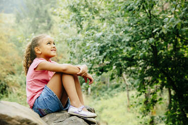 Mixed race girl sitting outdoors - BLEF11207