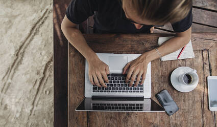 Caucasian man using laptop in cafe - BLEF11240