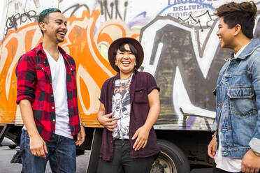 Friends laughing at graffiti wall - BLEF11363