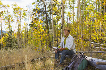 Man sitting in autumn forest - BLEF11420