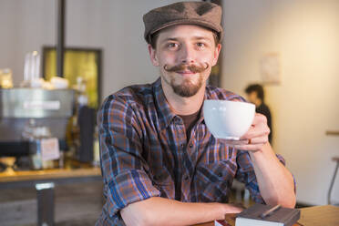 Caucasian man drinking coffee in cafe - BLEF11428