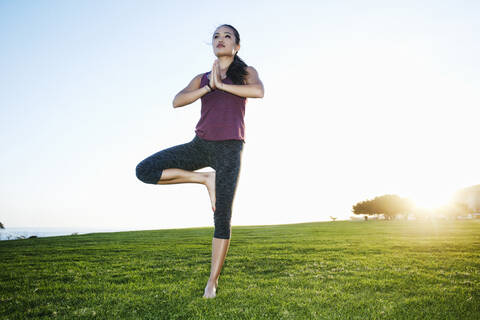 Asian woman practicing yoga outdoors stock photo