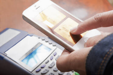 Hispanic woman paying with cell phone - BLEF11502