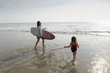 Mutter und Tochter spielen in den Wellen am Strand - BLEF11515