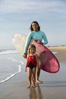 Mother and daughter smiling on beach - BLEF11516