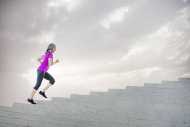 Kaukasische Frau joggt auf Stufen - BLEF11635