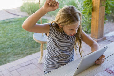 Caucasian girl cheering at digital tablet - BLEF11661