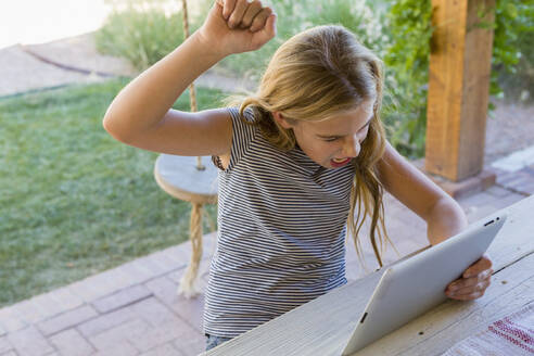 Kaukasisches Mädchen jubelt über eine digitale Tafel - BLEF11661