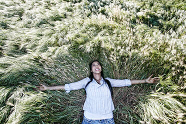 Mixed race woman laying in grass - BLEF11666