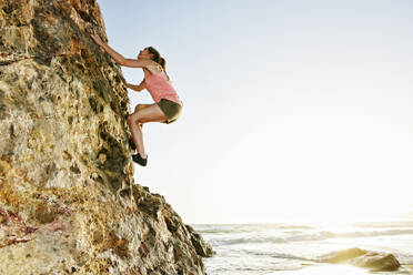 Woman climbing rock formation - BLEF11728