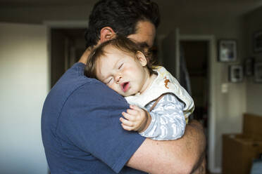 Kaukasischer Vater hält schlafendes kleines Mädchen - BLEF11834